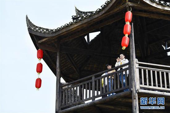  游客在重慶市武隆區(qū)黃鶯鄉(xiāng)復(fù)興村的觀景樓上欣賞田園景色（2019年3月28日攝）。 新華社記者 劉潺 攝