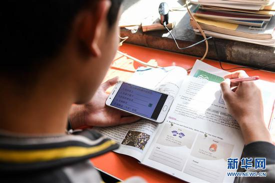  3月10日，內(nèi)蒙古準(zhǔn)格爾旗龍口鎮(zhèn)紅樹(shù)梁村的初一學(xué)生劉進(jìn)才在家中上網(wǎng)課。 新華社記者 劉磊 攝